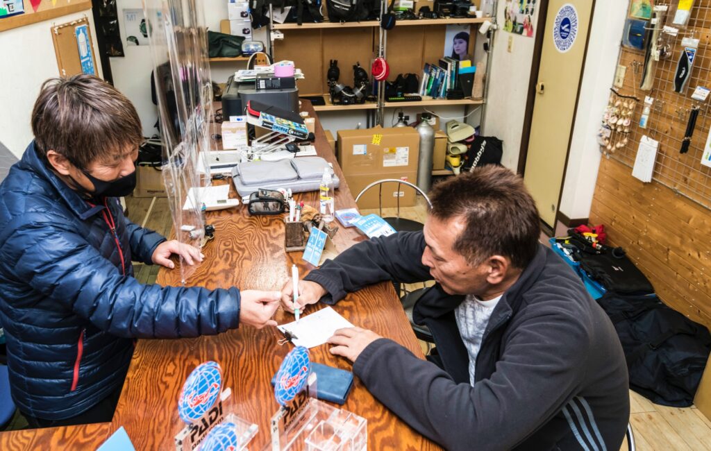 翌日のツアーガイドのために尾鷲から帰ってきたスタッフに海況や生物の様子を聞く中村さん